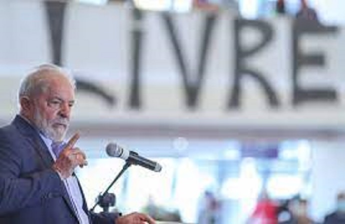 Lula discursa e, ao fundo, uma faixa Livre