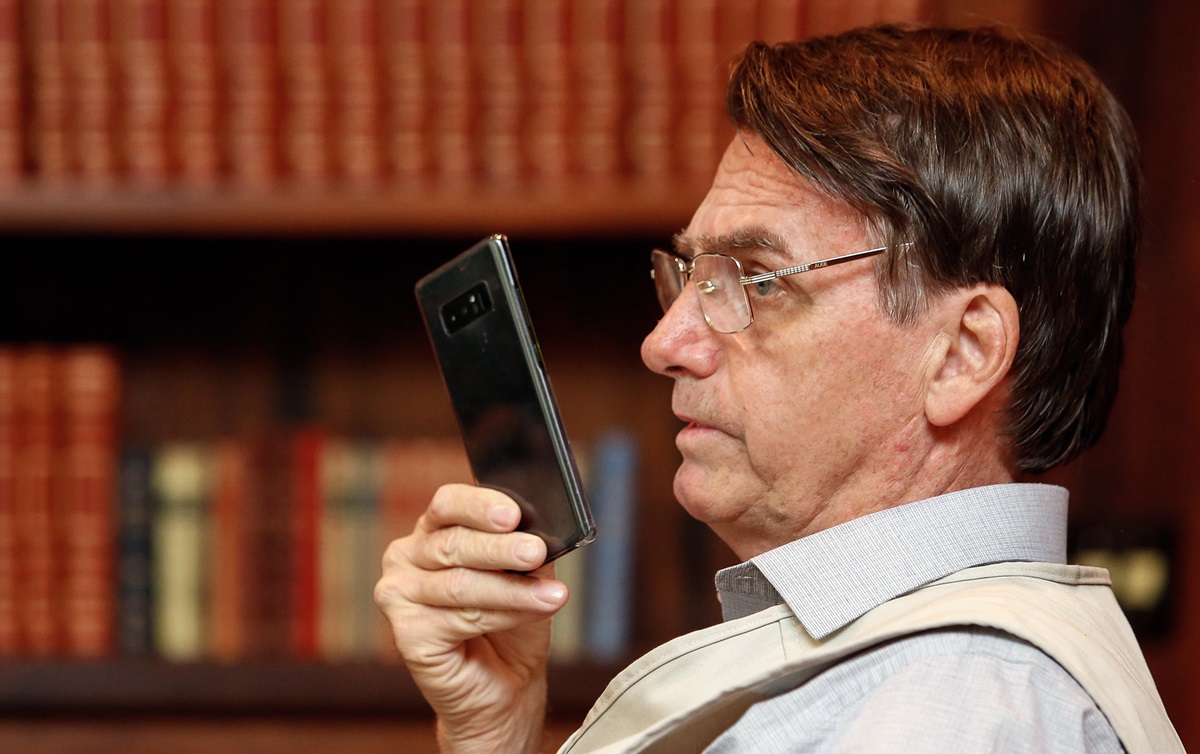 Jair Bolsonaro em foto de perfil, segundando um celular