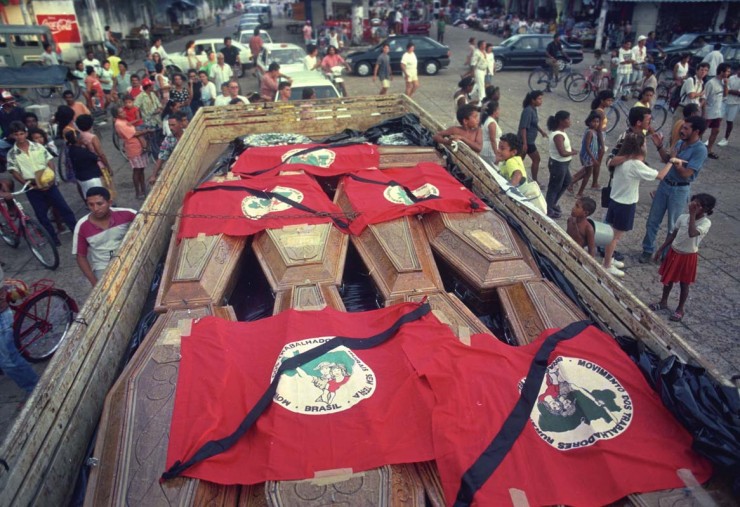 Caixões dos mortos no massacre de sem-terras levados para enterro cobertos por bandeiras do MST - Foto: Arquivo