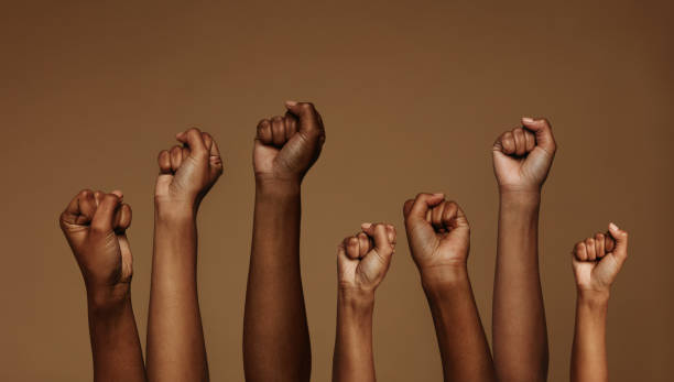 Cropped shot of hands raised with closed fists. Multiple hands raised up with closed fist symbolizing the protests movement.