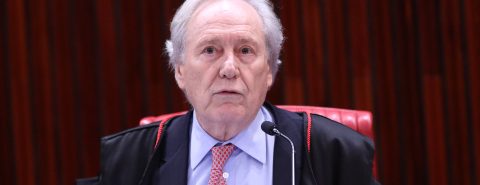 O ministro do TSE Ricardo Lewandowski com a capa preta por cima de uma camisa azul e gravata vermelha