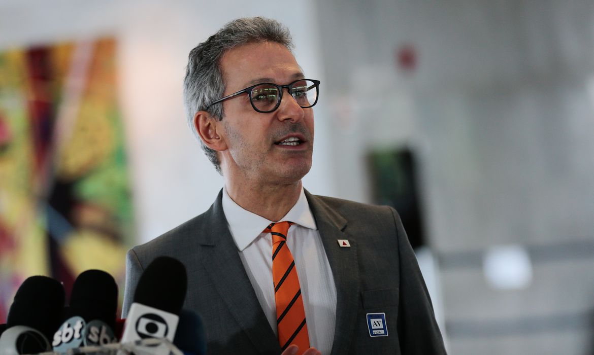 Romeu Zema de terno e gravada laranja