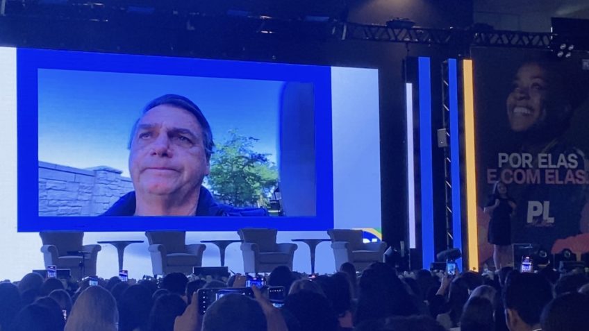 Em telão, Bolsonaro participou virtualmente do lançamento de Michelle Bolsonaro no PL - Foto: Reprodução