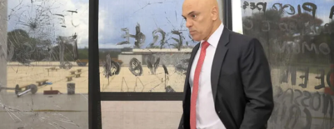 O ministro Alexandre de Moraes em frente a prédio depredado por golpistas.