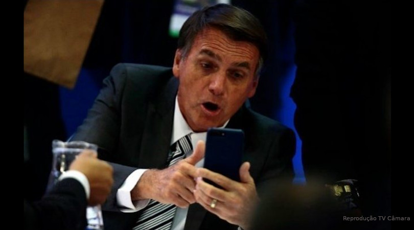 Bolsonaro assustado segurando o celular