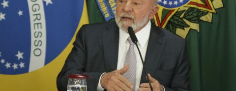Presidente Lula em coletiva falando diante do microfone.