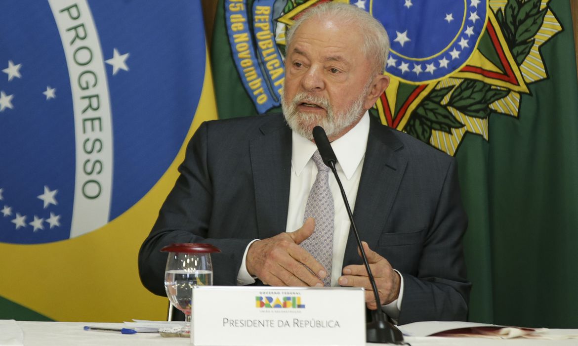 Presidente Lula em coletiva falando diante do microfone.