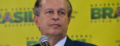 Renato Janine é fotografado em diante da logomarca do governo federal