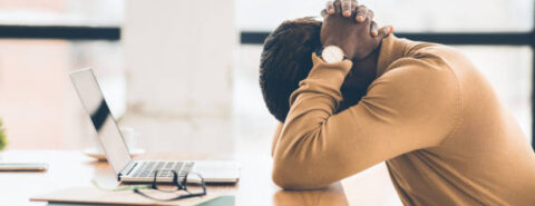 Problems At Work. Black businessman feeling upset and desperate, working at office, hands on head. Free space