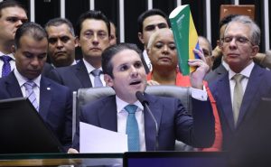 Hugo Motta segura o livro da Constituição brasileira