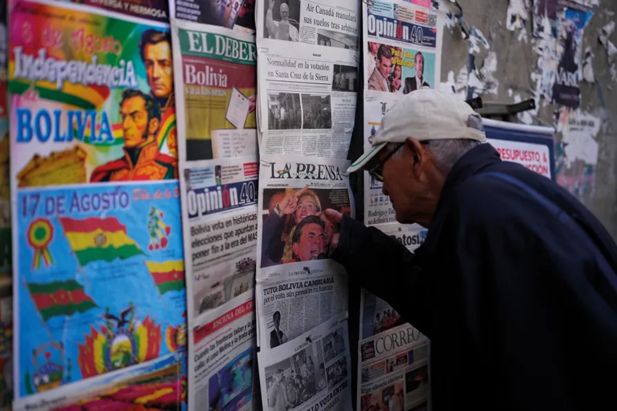 Um homem olha as manchetes de jornal no dia seguinte às eleições presidenciais e legislativas em La Paz, Bolívia.